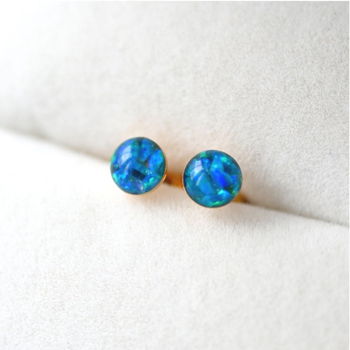 Thoughtful memorial jewellery – small 4mm stud earrings with ashes and opal flakes, available in sterling silver or gold-filled.