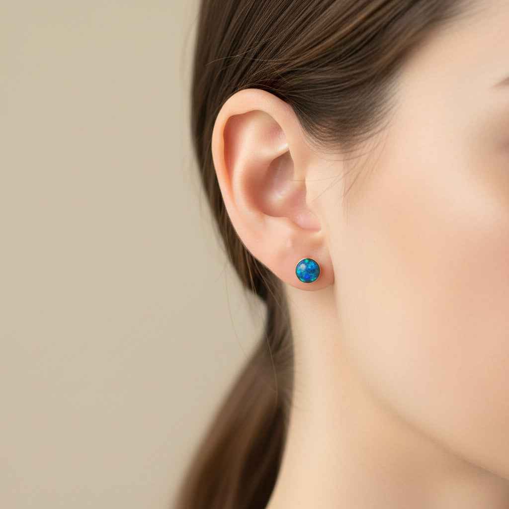 Close-up of 4mm memorial stud earrings with opal flakes and ashes, set in sterling silver or gold-filled.