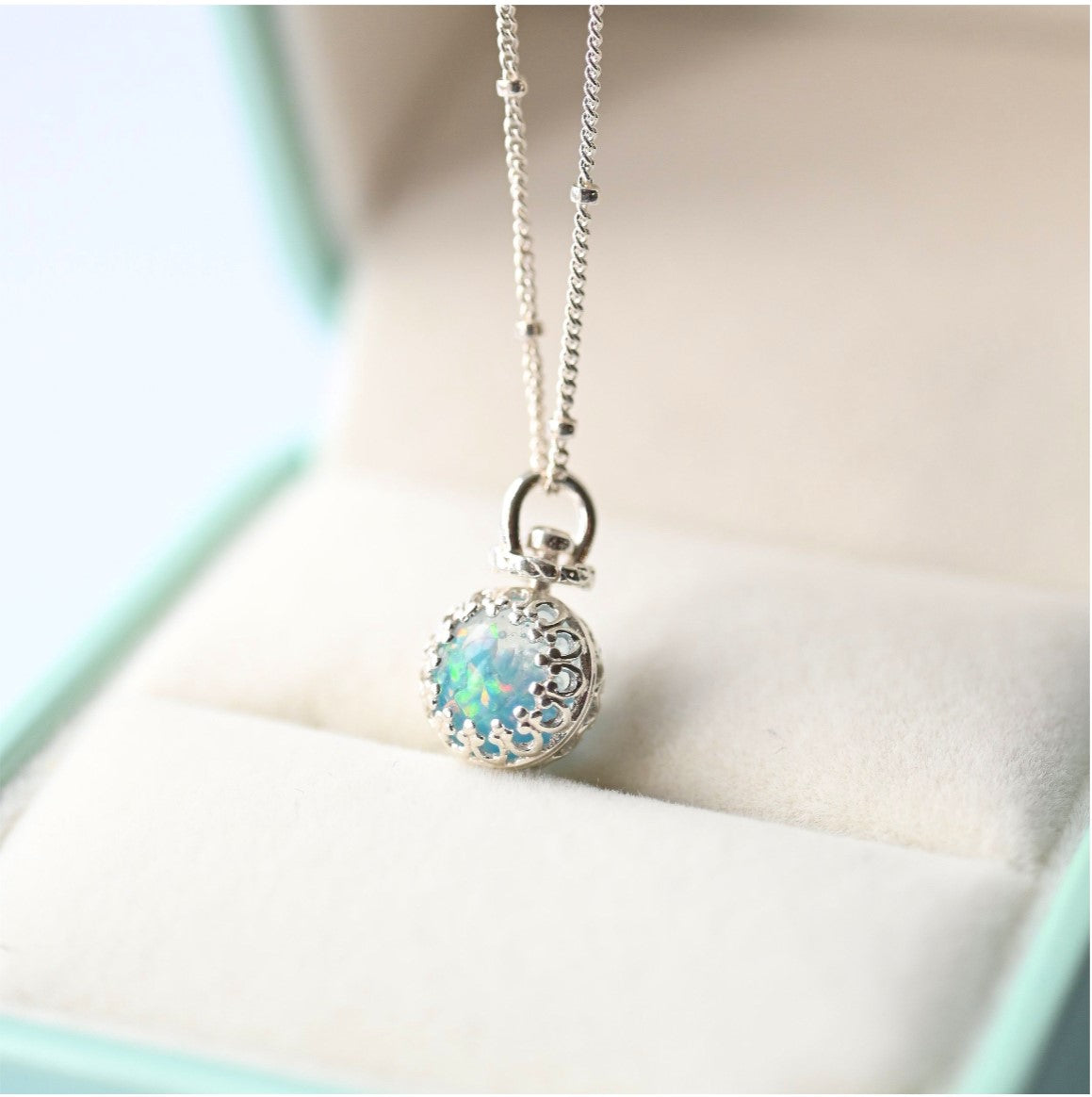 Elegant sterling silver 8mm ball pendant necklace with cremation ashes and opal flakes, suspended on an 18-inch chain.