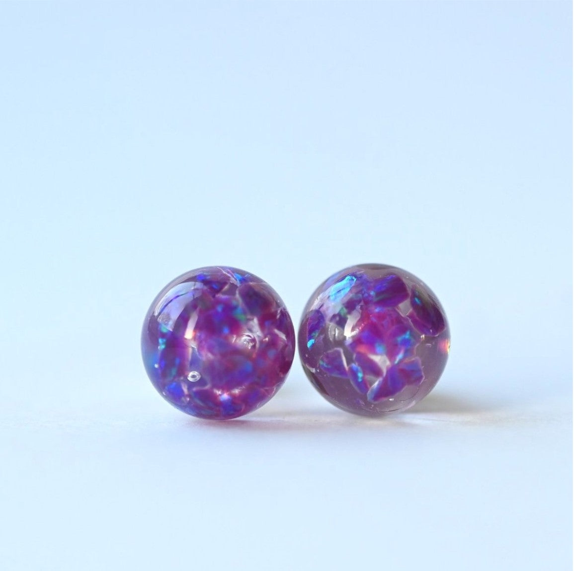 Close-up of 8mm memorial stud earrings with crushed opals and ashes, handcrafted in silver or gold-filled, made in the UK for a meaningful and lasting keepsake.