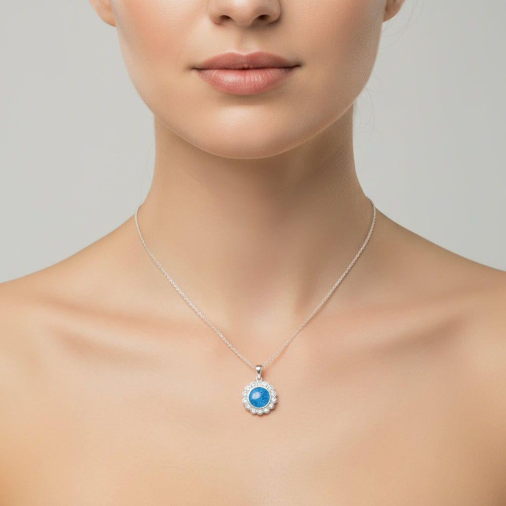 Necklace with a blue pendant worn by a person on a neutral background