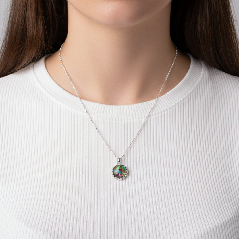 Close-up of a necklace with a colorful pendant worn by a person against a white background