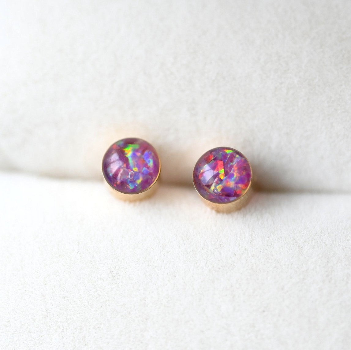 Side view of handcrafted 4mm gold-filled stud earrings with preserved ashes and opal, a meaningful remembrance piece.