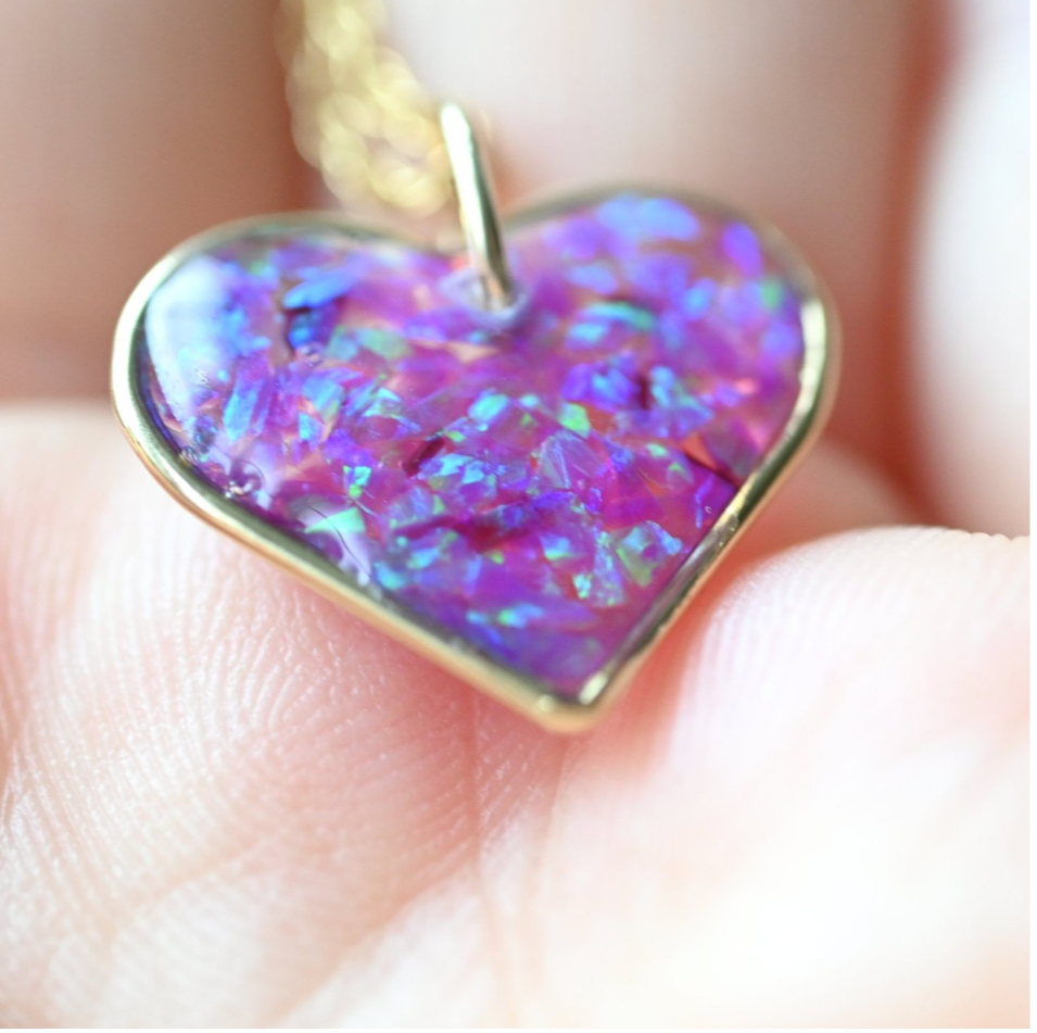 Close-up of a 17.5mm gold-filled heart pendant infused with ashes or hair and opal flakes, a sentimental memorial necklace made in the UK.