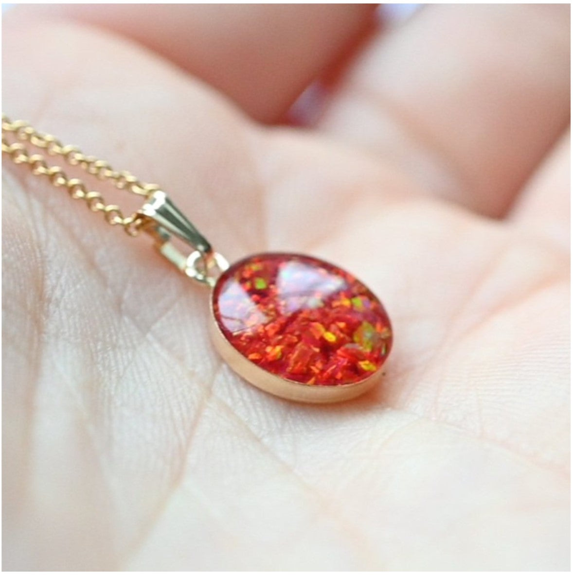 Close-up of Gold-Filled Memorial Necklace with Iridescent Opal Flakes – A detailed view of the custom memorial necklace featuring ashes or hair and iridescent opal flakes in a gold-filled setting.