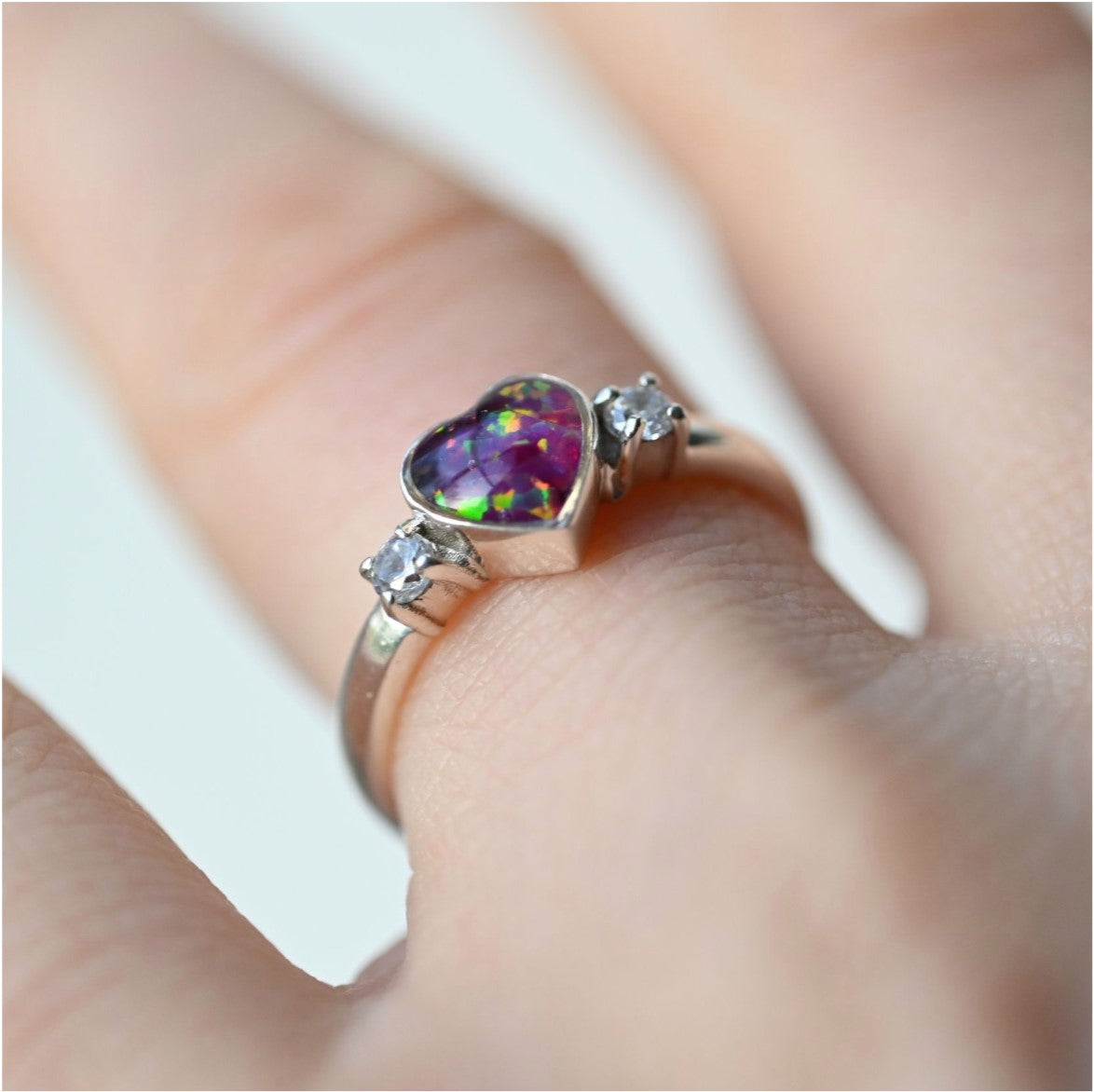 Close-up of a heart-shaped double gem memorial ring with ashes, offering a handmade sterling silver design for a personalised tribute.