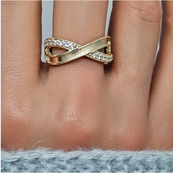 9ct yellow gold infinity CZ crossover ring worn on finger lifestyle shot