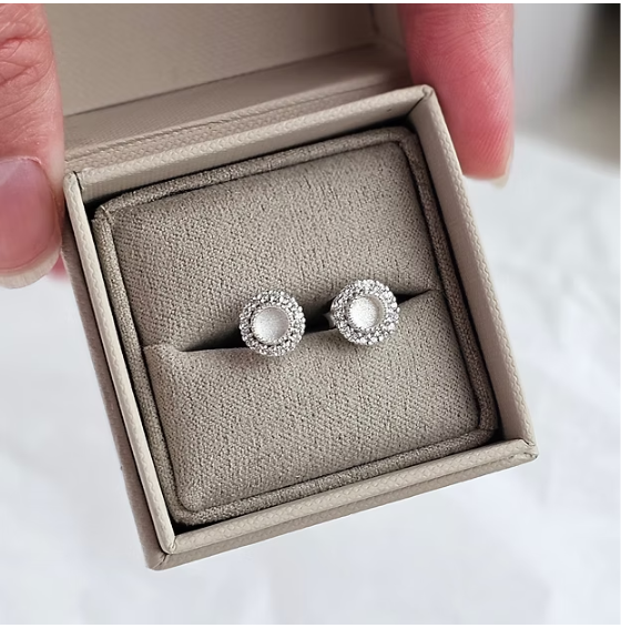 Silver 925 CZ halo stud earrings in box held in hand