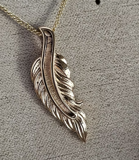 9ct yellow gold feather pendant on chain, front view showing intricate 3D barb texture and central spine channel