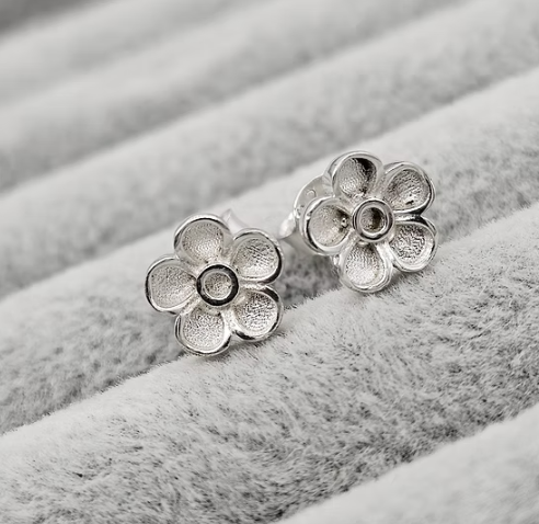 Silver 925 forget-me-not flower stud earrings close up on grey velvet — blank silver