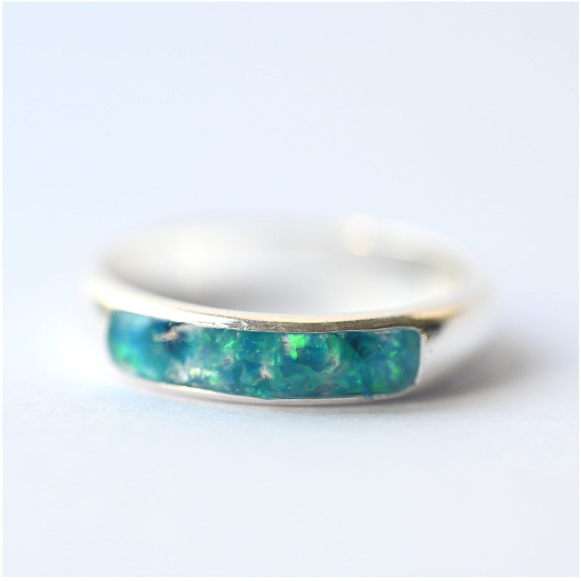 Close-up of ladies silver channel ring with opals and memorial ashes, showcasing intricate design and craftsmanship.