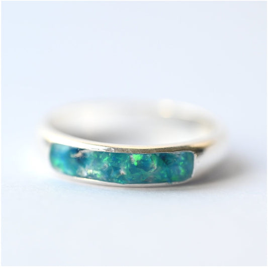 Close-up of ladies silver channel ring with opals and memorial ashes, showcasing intricate design and craftsmanship.
