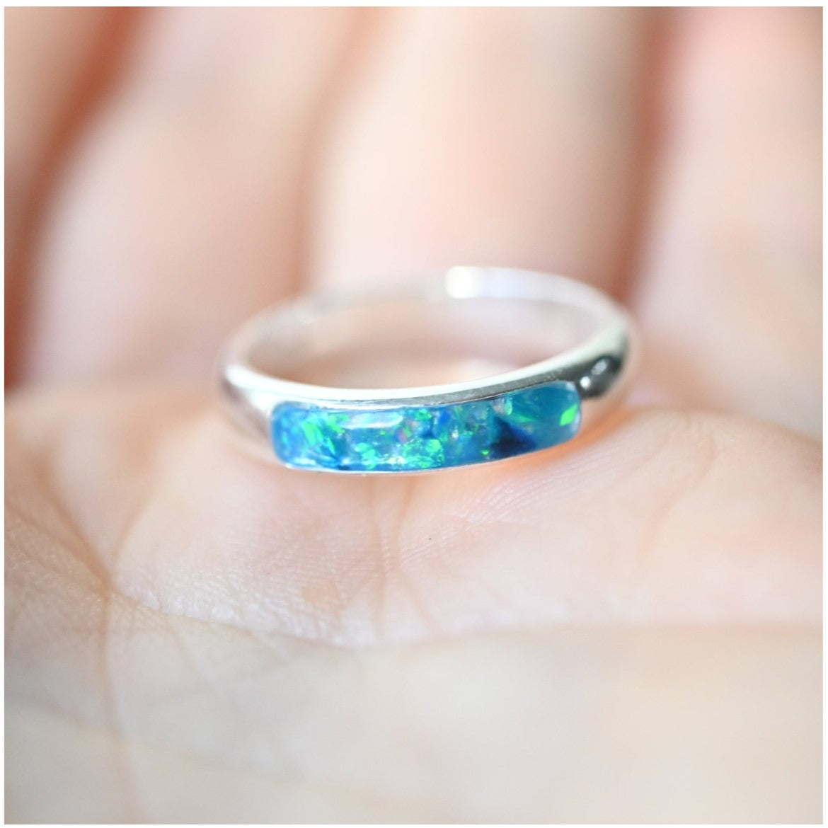 Ladies silver channel ring with opals and a small amount of memorial ashes, creating a sentimental tribute.