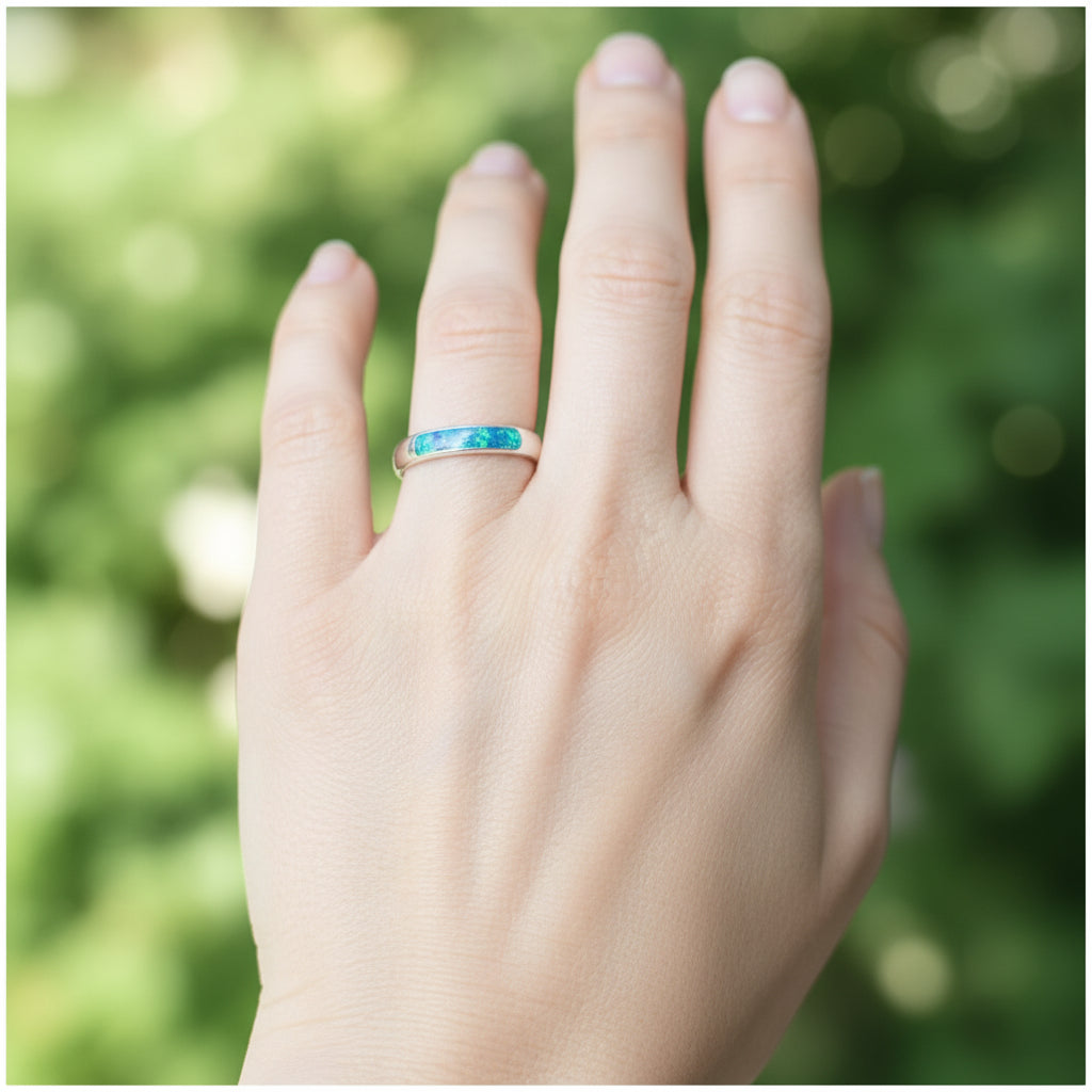 Side view of the ladies silver channel ring, highlighting the opals and memorial ashes set within the band.