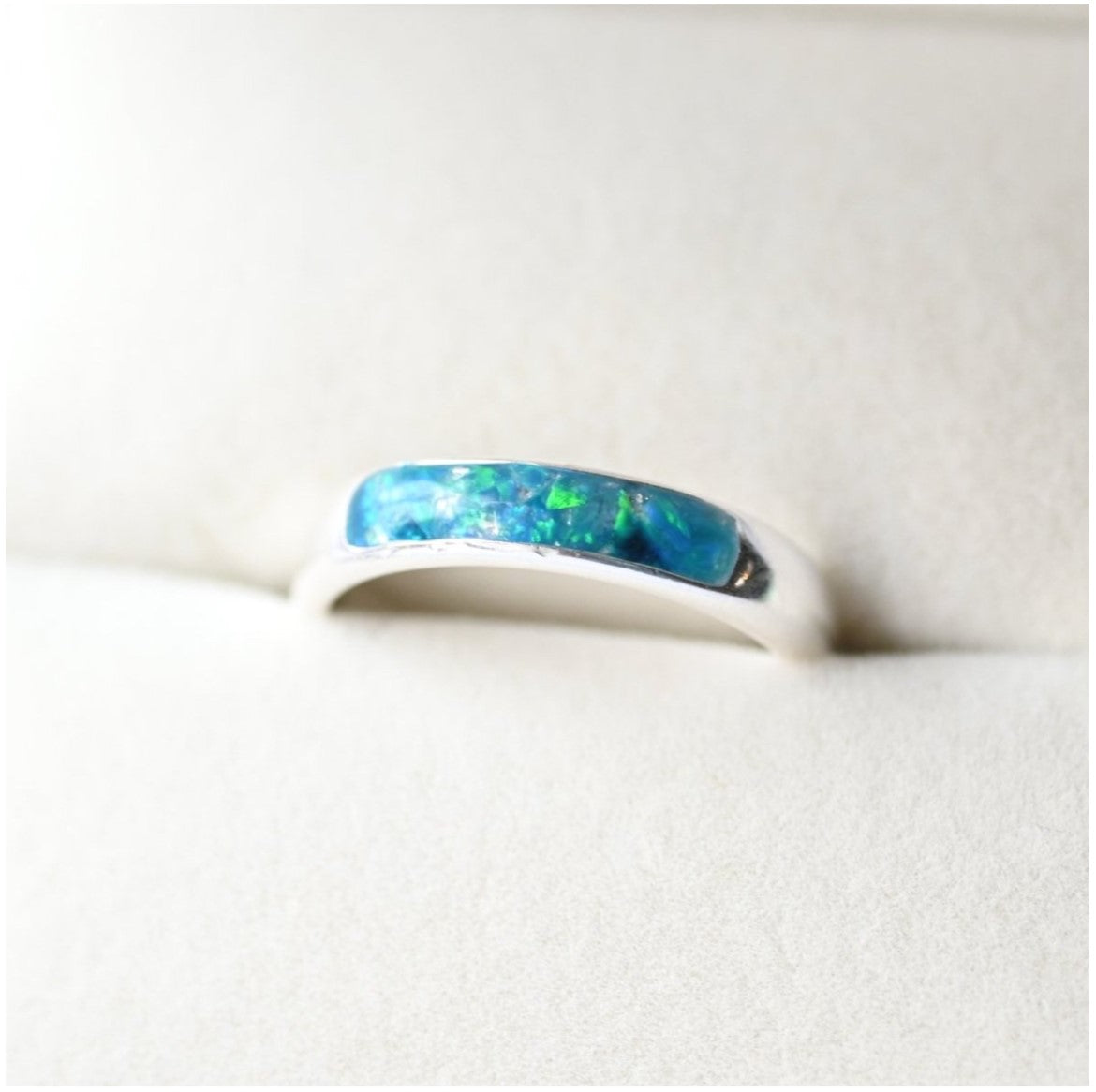 Ladies silver channel ring with opals and a small amount of memorial ashes, creating a sentimental tribute.