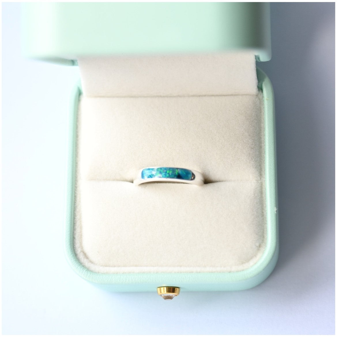 Ladies silver channel ring with opals and a small amount of memorial ashes, creating a sentimental tribute.