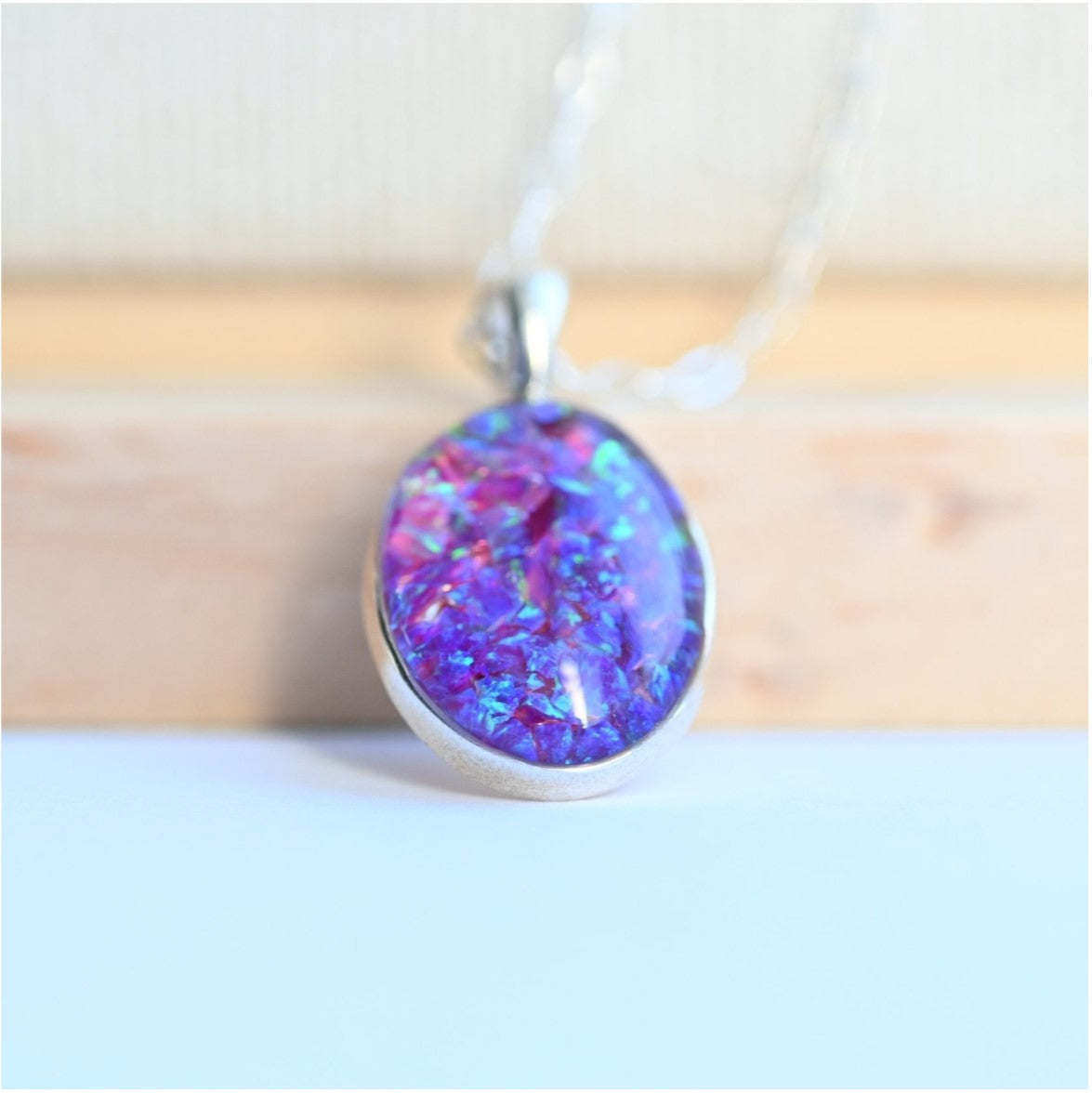 Side View of Memorial Oval Pendant with Opal Flakes & Silver Chain – A side profile of the oval pendant, highlighting its opal flakes and attached to a sterling silver chain.