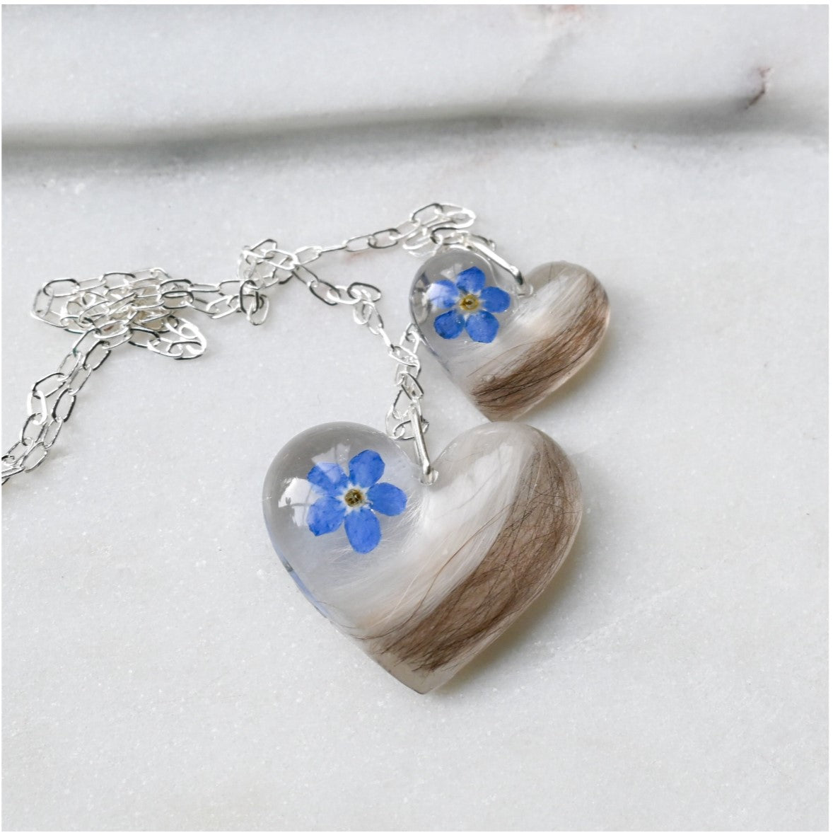 Sterling Silver Pet Fur Keepsake Necklace with Forget-Me-Not Flower – A sentimental fur memorial necklace with small (18mm) and large (24mm) heart pendants, preserving pet fur in resin.