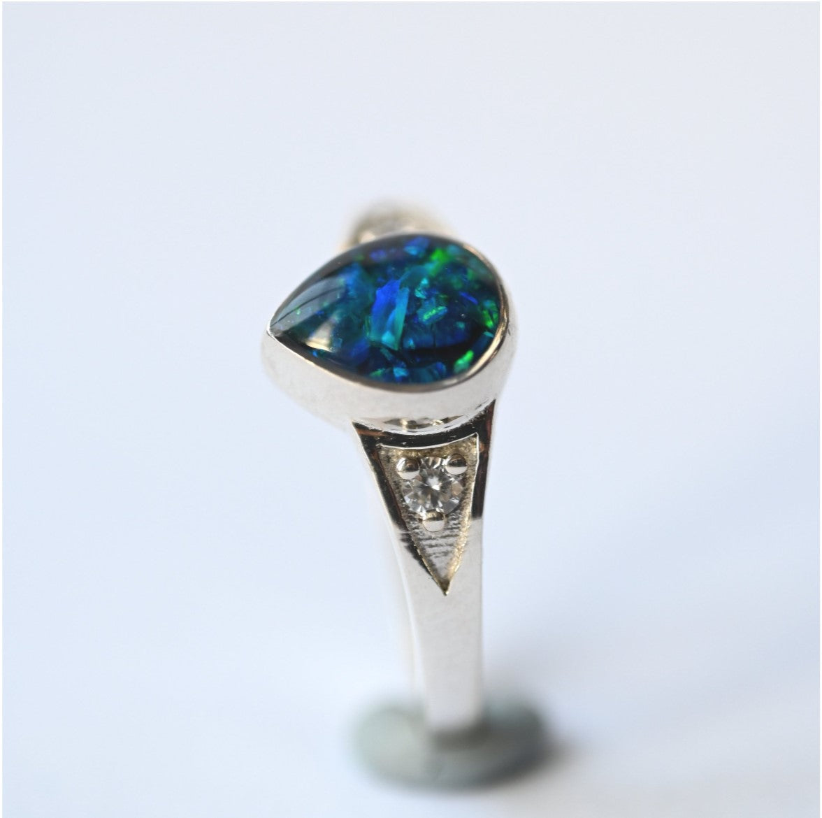 Side View of Teardrop Memorial Ring in Silver with Opal Flakes – A detailed side angle showcasing the elegant teardrop setting, with opal flakes adding a subtle shimmer to the memorial ashes.