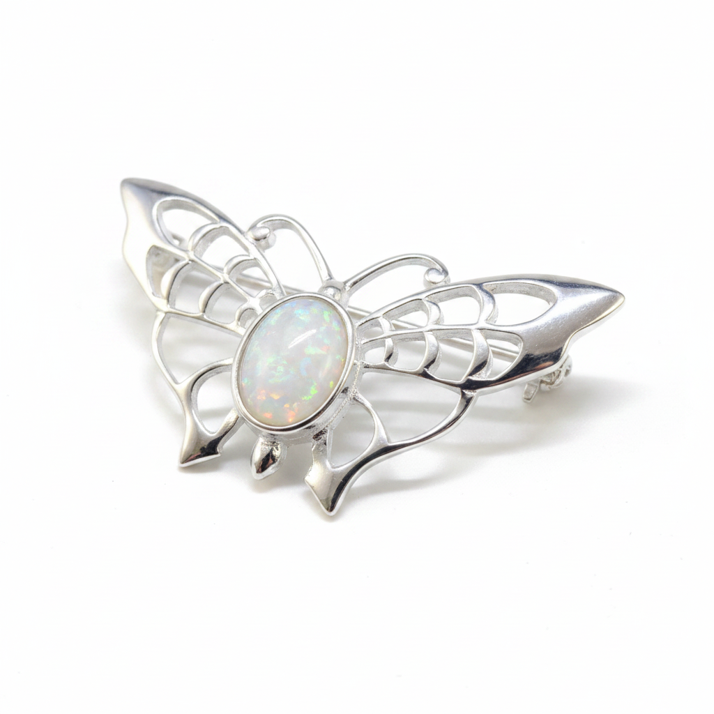 Silver 925 filigree butterfly brooch with white pearl opal resin in 8x6mm central bezel on white background