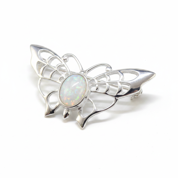 Silver 925 filigree butterfly brooch with white pearl opal resin in 8x6mm central bezel on white background