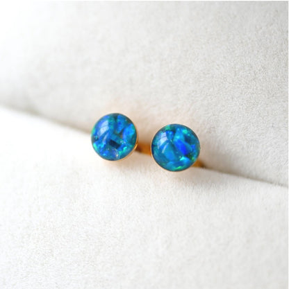 Thoughtful memorial jewellery – small 4mm stud earrings with ashes and opal flakes, available in sterling silver or gold-filled.