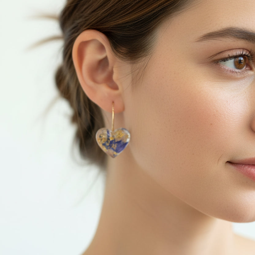 Heart-shaped earrings with floral design worn by a model