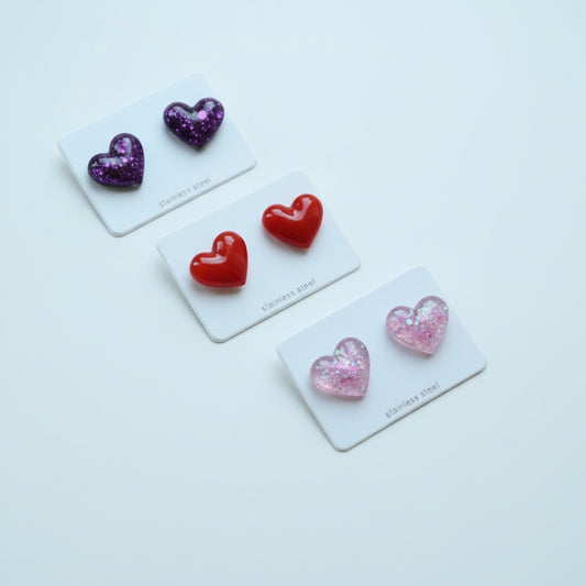 Assorted heart-shaped earrings on display with a white background