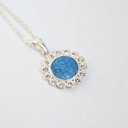 Blue pendant necklace with silver chain on a light gray background