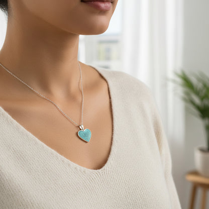 Woman wearing a necklace with a heart-shaped pendant in a blurred indoor setting