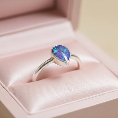 Silver ring with a heart-shaped purple opal stone on a light background