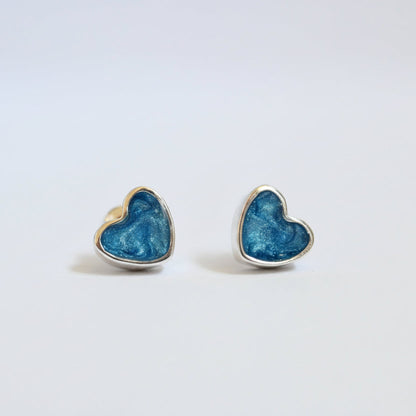 Heart-shaped blue earrings on a light gray background