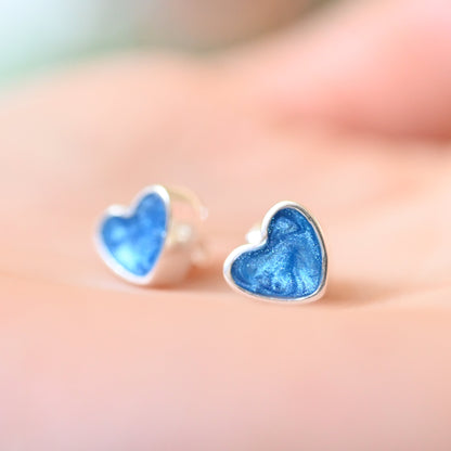 Heart-shaped blue earrings on a blurred background