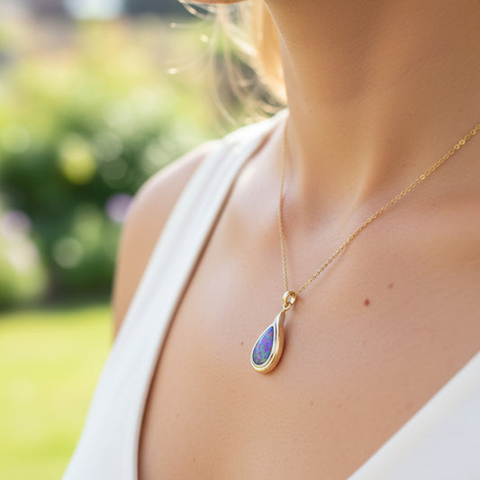 Opal pendant with gold setting on a hand