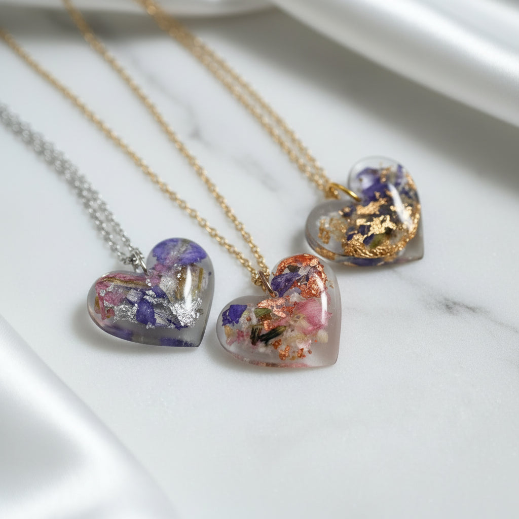 Heart-shaped necklaces with floral designs on a light background