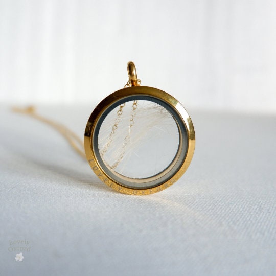 Gold locket with a white marble-like interior on a light gray background