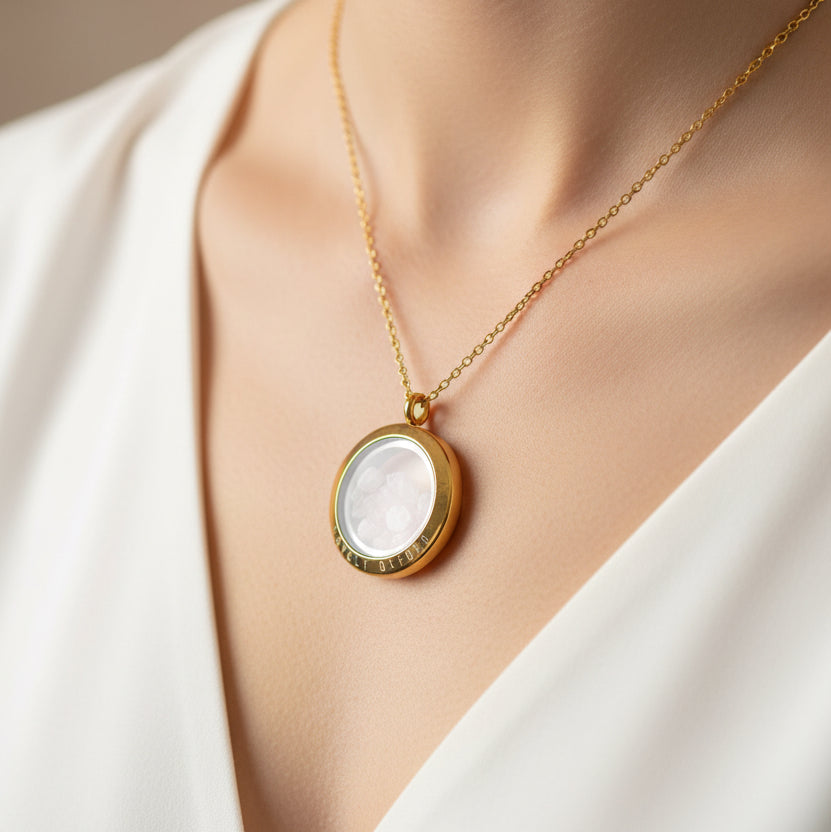 Gold locket with crystals and 'Lovely Oxford' engraving on a light background