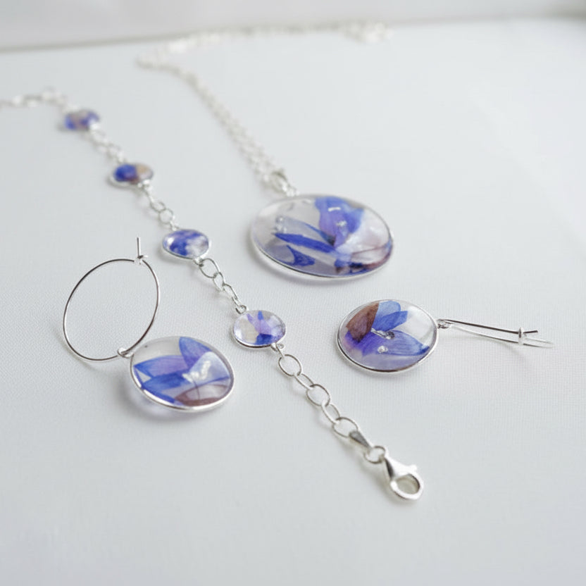 Jewelry set with blue floral designs on a white surface
