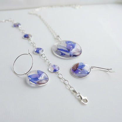 Jewelry set with blue floral designs on a white surface