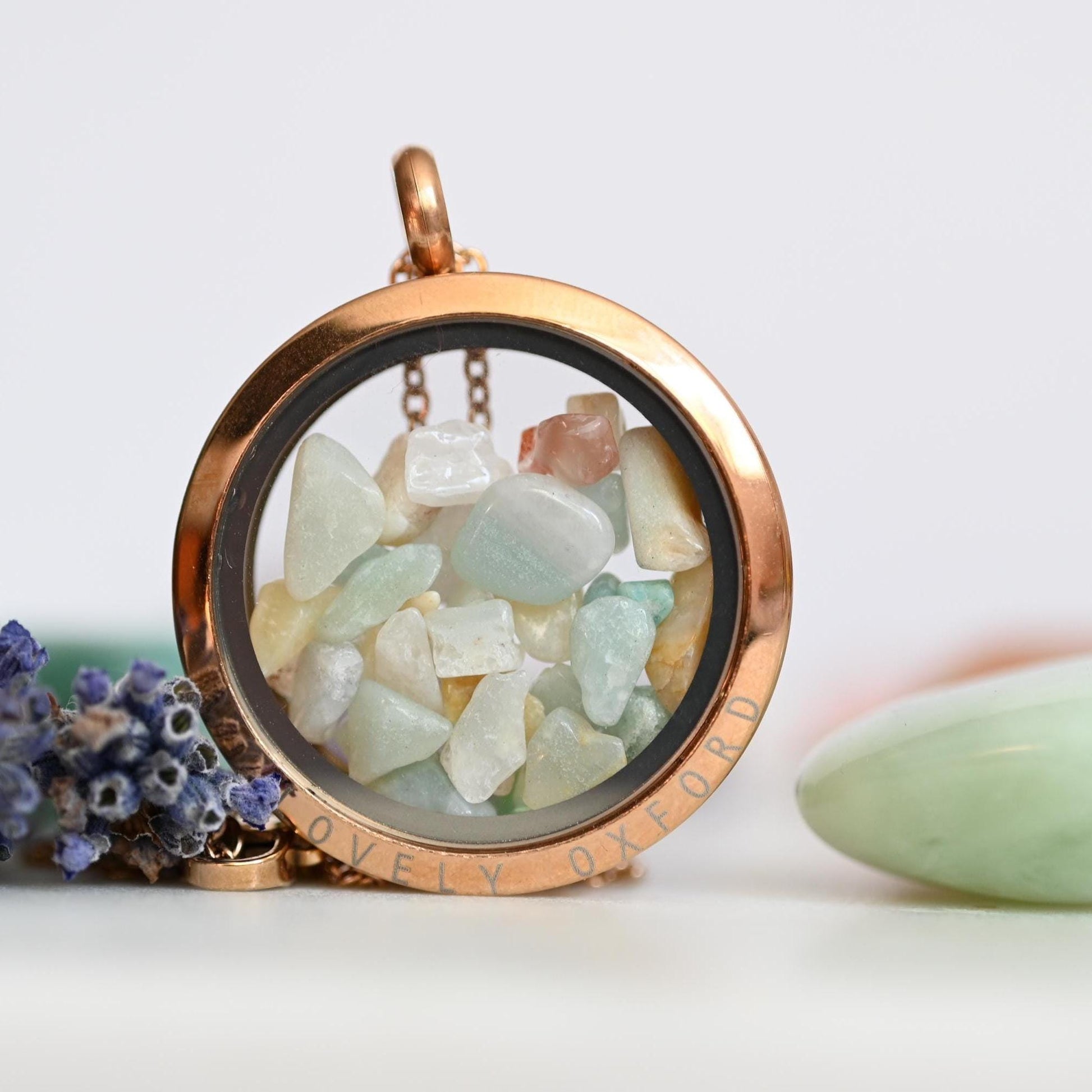 Rose gold locket with sea glass and lavender on a white background
