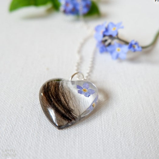 Heart-shaped pendant with floral design on a white background