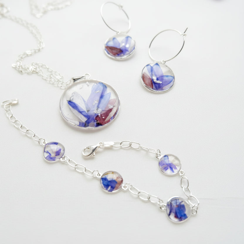 Silver jewelry set with floral elements on a white background
