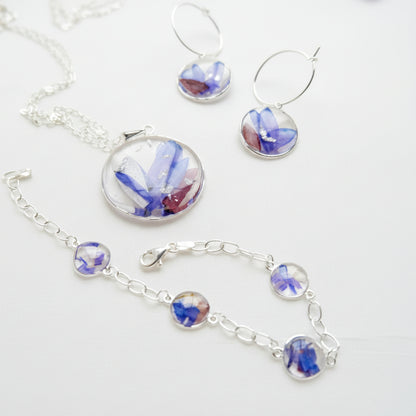 Silver jewelry set with floral elements on a white background
