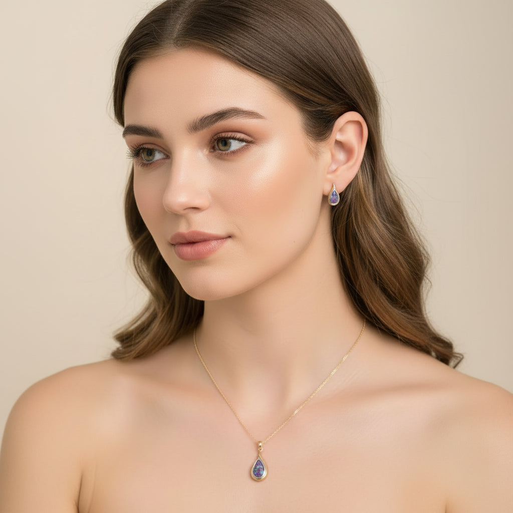 Woman wearing a gold necklace with a teardrop pendant and matching earrings.