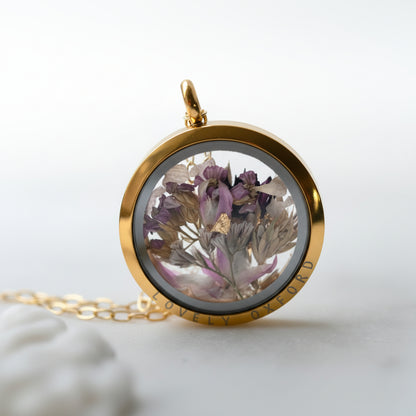 Gold locket with dried flowers on a white background