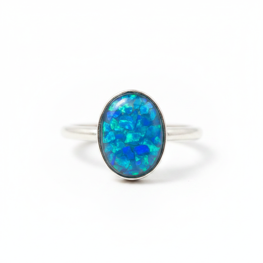 925 sterling silver oval cabochon memorial ring with blue teal opal flakes in oval bezel on white background