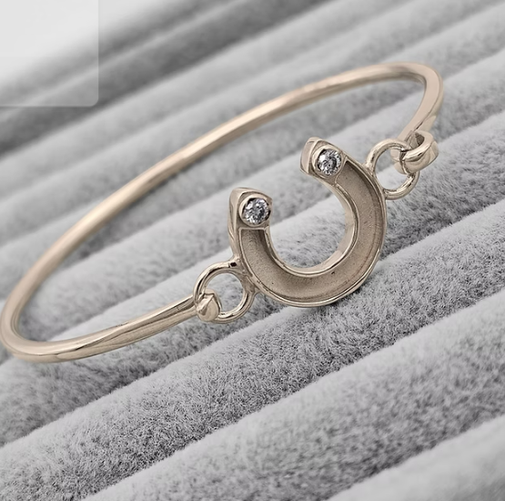 9ct yellow gold horseshoe CZ hook clasp bangle showing horseshoe centrepiece with CZ bezel stones and fine wire band