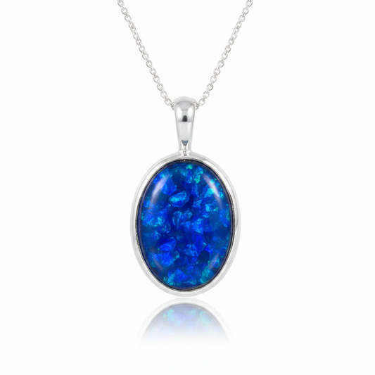 Plain silver 925 oval bezel memorial pendant with blue opal flakes, white background