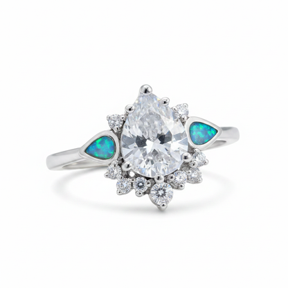 Silver 925 CZ dewdrop cluster ring with blue teal opal resin in tapered shoulder channels on white background