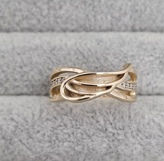 9ct yellow gold angel wing CZ ring front view on grey velvet